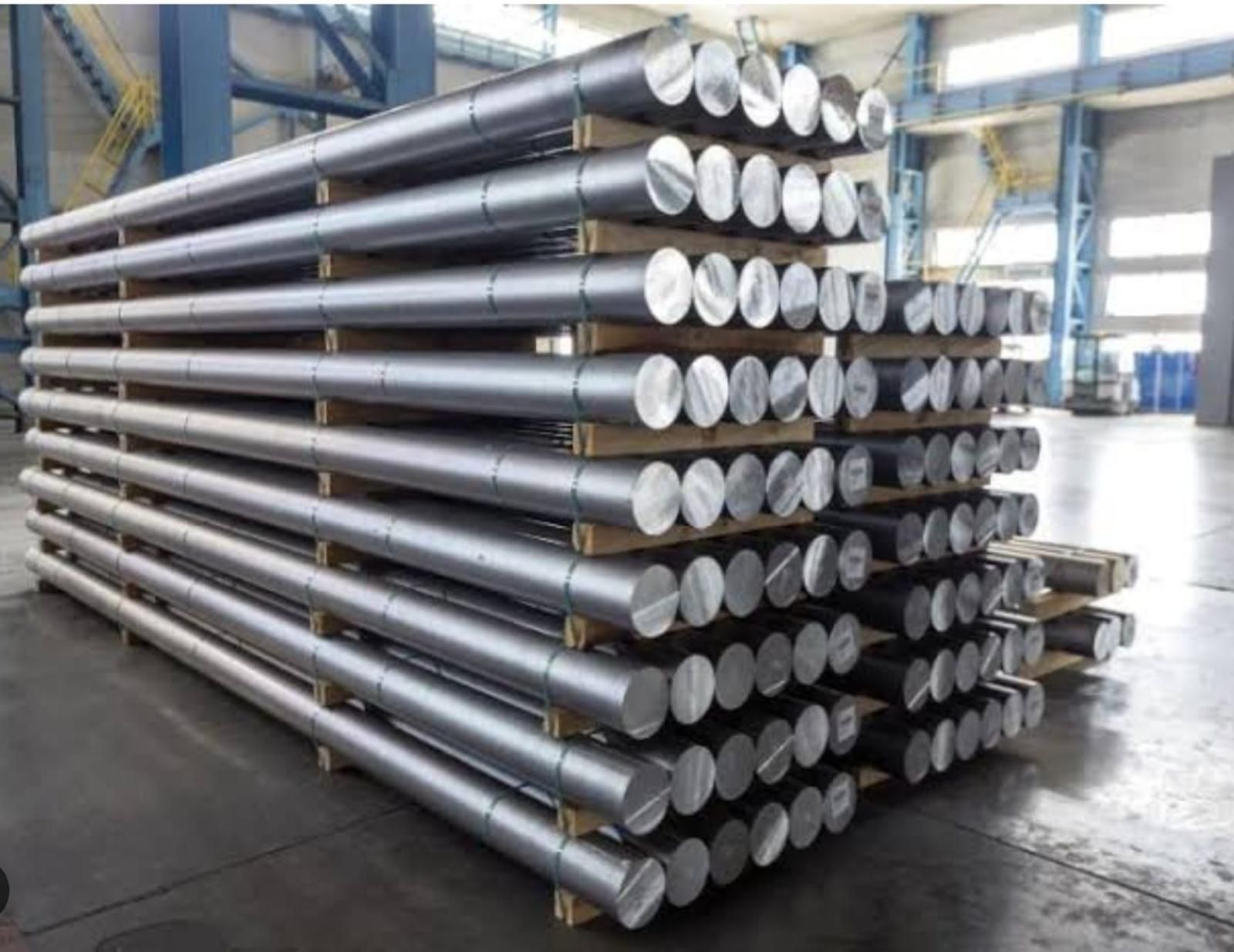 Aluminium billets banded on timber pallets and stacked in an indoor storage bay